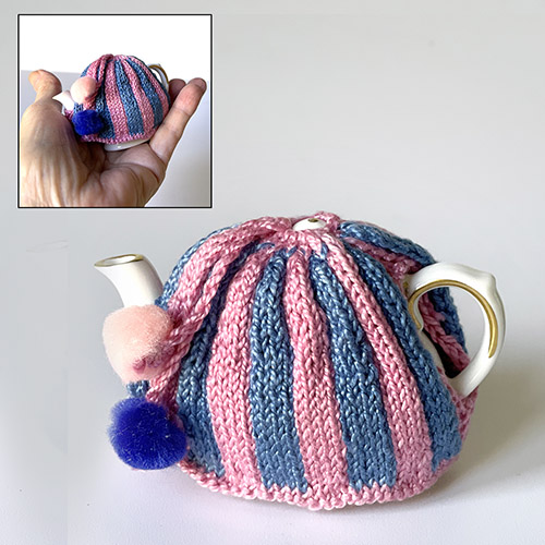 Hand knitted miniature tea cosy in blue and pink stripes worn by miniature Coalport teapot