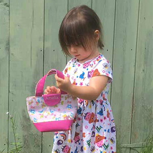 Little girl holding toy tote handbag